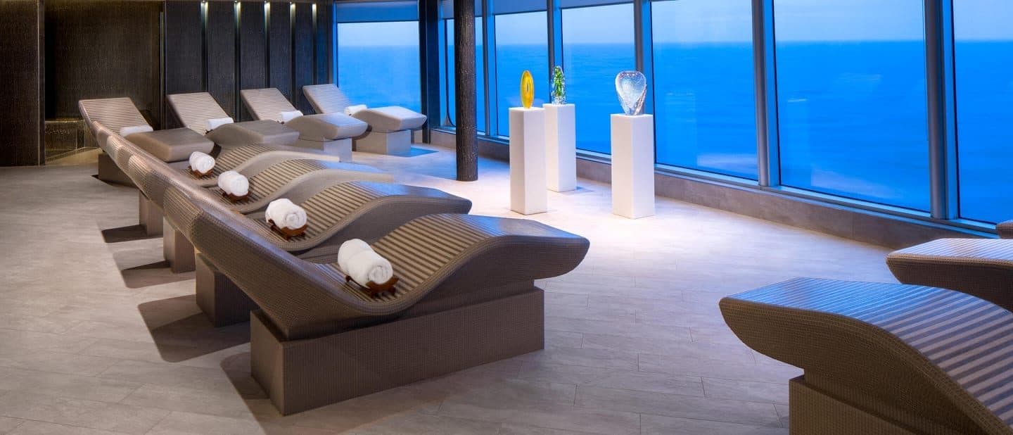 Thermal suite loungers facing large ocean-view windows on Holland America ship.