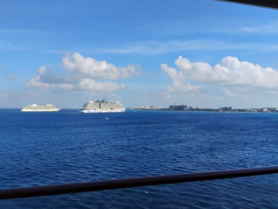 Three cruise ships on the horizon off a Caribbean island